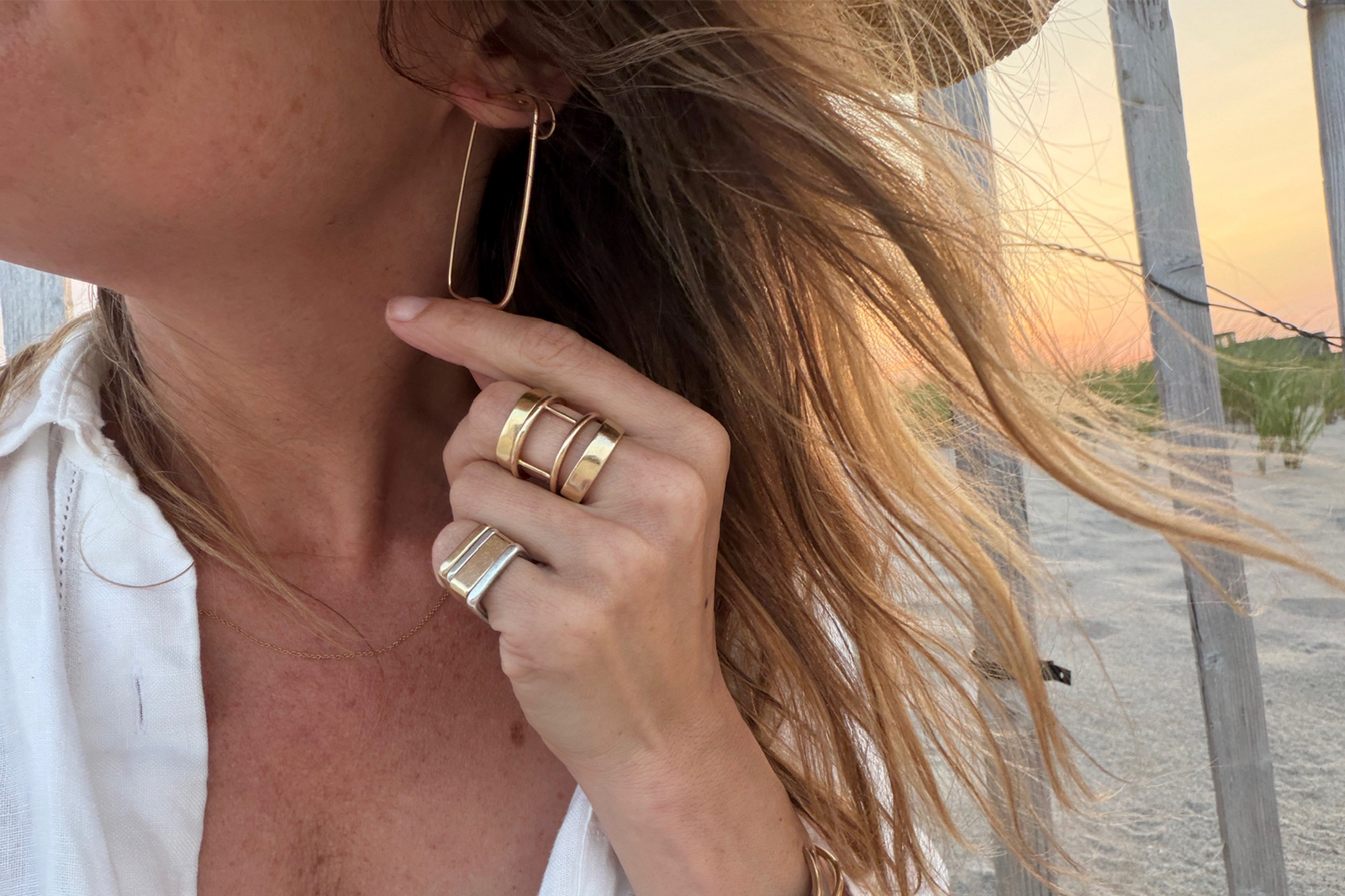 Colleen Mauer wearing lightweight continuous hoop earrings and stacked rings at the beach