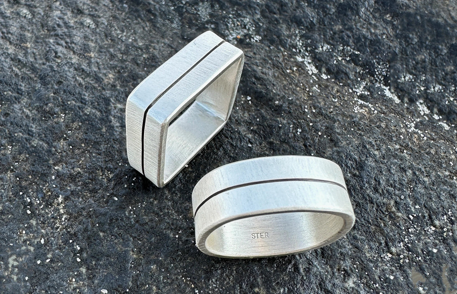 square and round sterling silver virgo rings with oxidized handcarved lines pictured on the beach