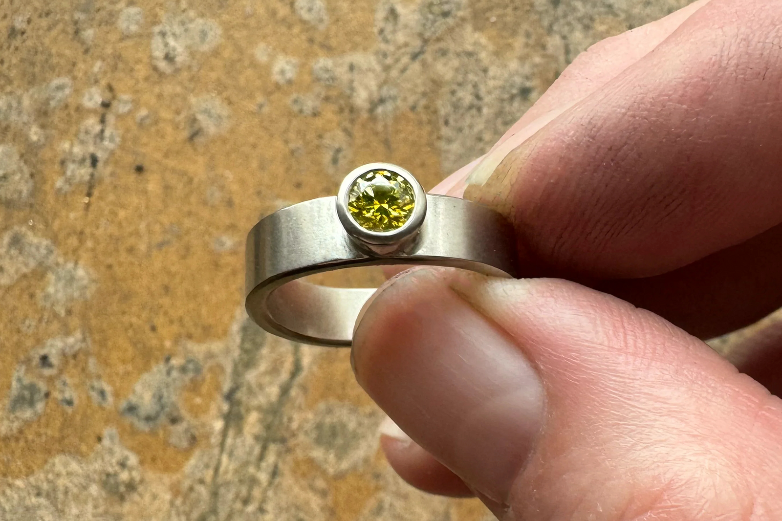Custom 14k white gold ring featuring Bert's bezel-set yellow memorial diamond