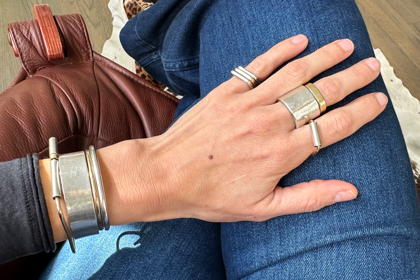 Colleen Mauer wearing the wide sterling silver CMD Armor Ring with mixed metal rings and bracelets