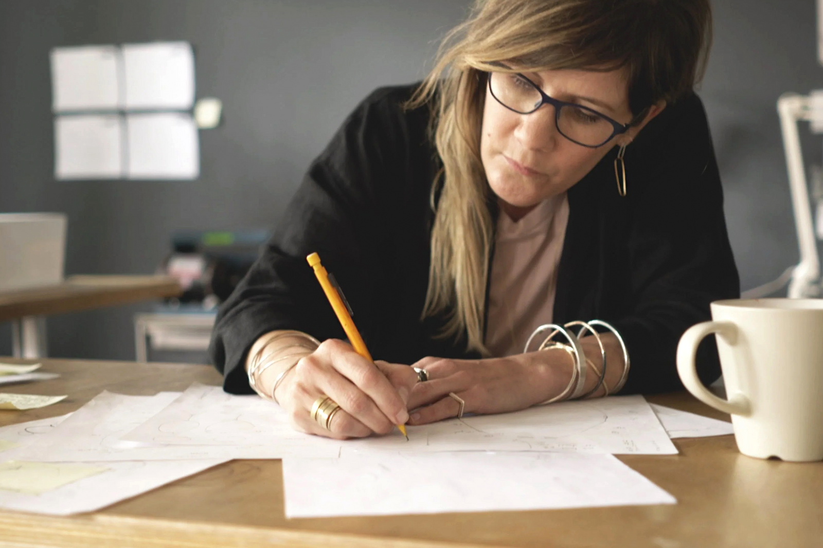 Colleen Mauer sketching jewelry designs at her worktable