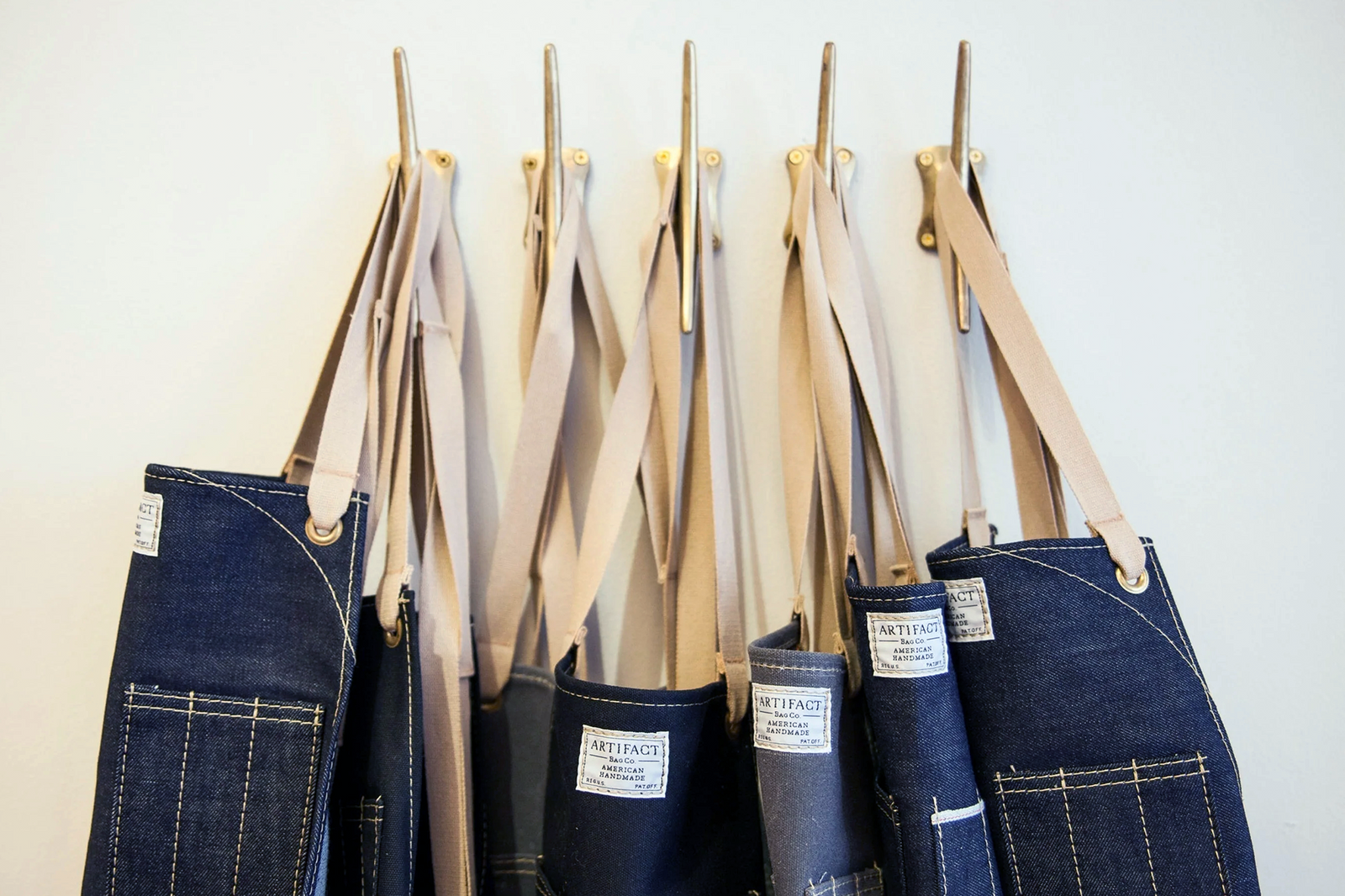 CMD studio aprons hanging together, representing the small Colleen Mauer Designs team