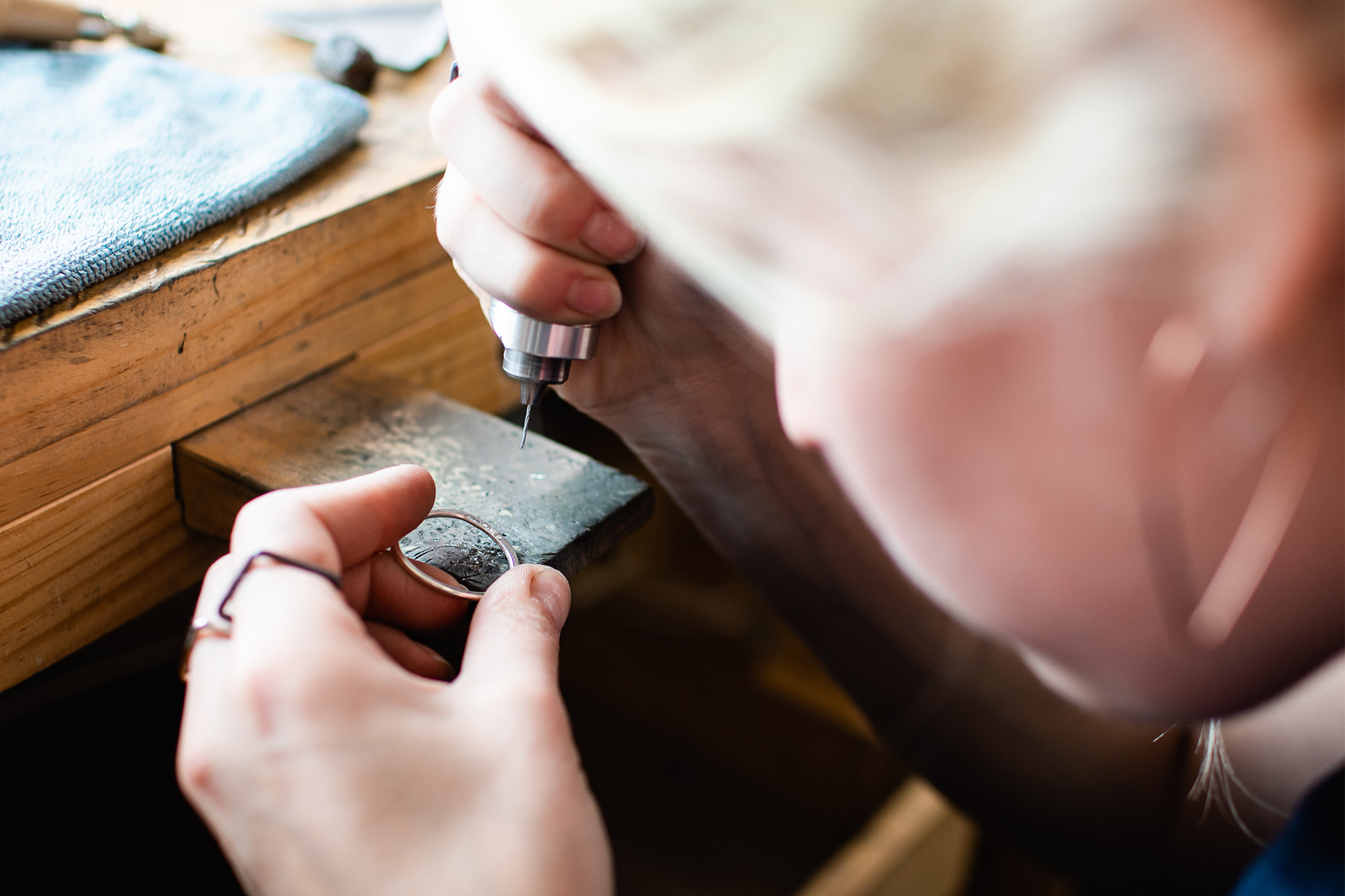Sam handcrafting CMD jewelry setting diamonds at the workbench in the Upstate New York production studio